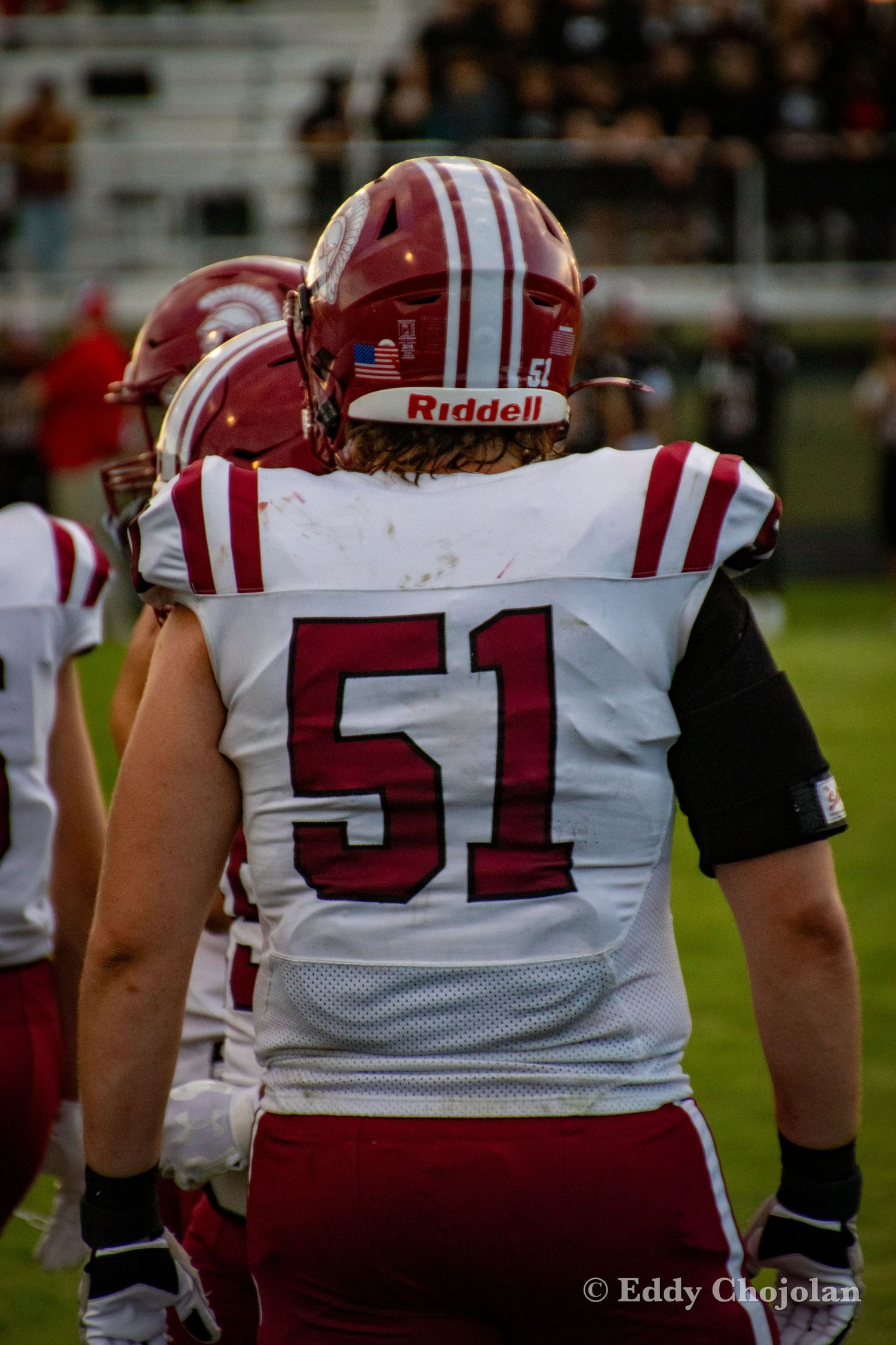 Football players in red and white uniforms lined up on the field during a game.