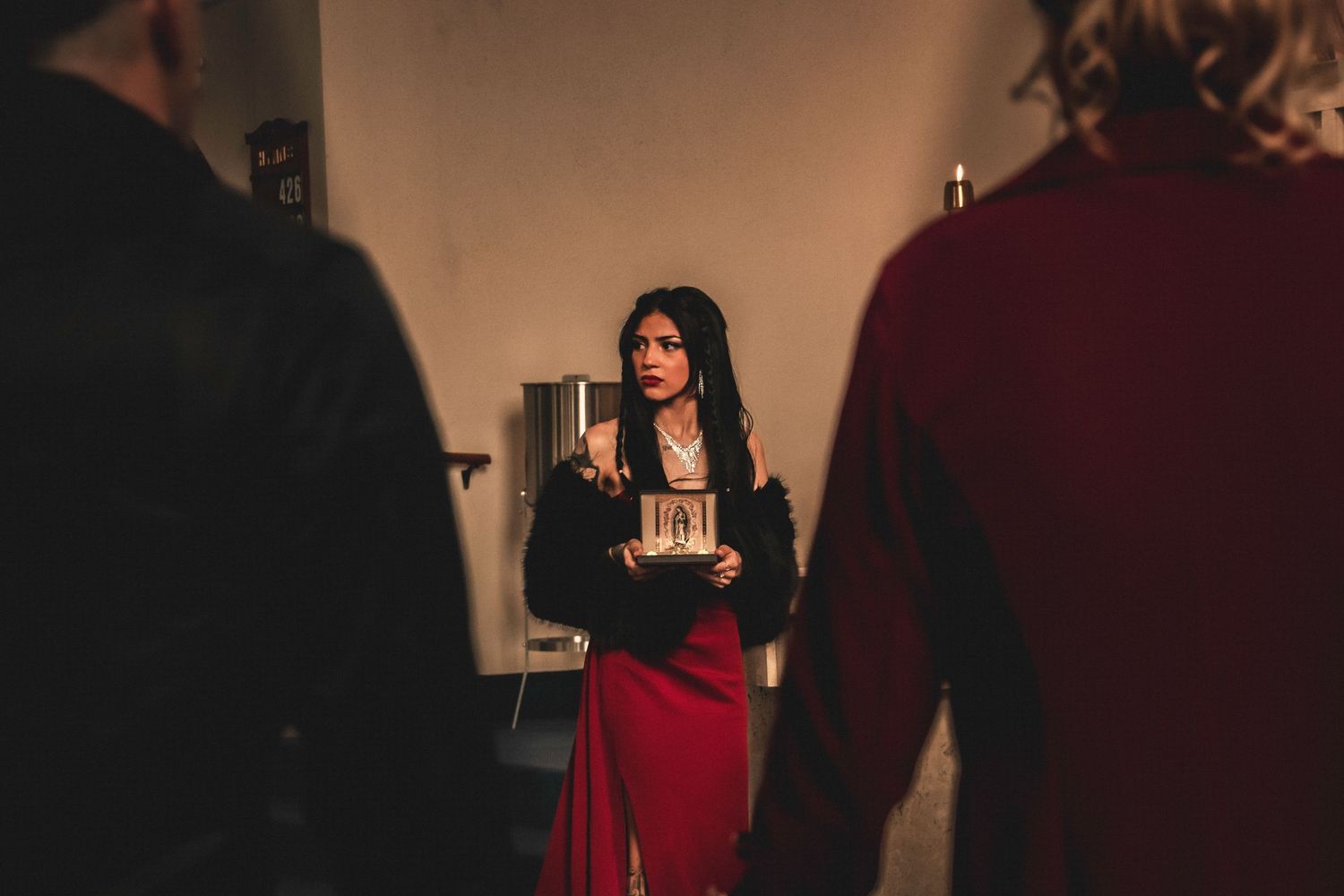 A dimly lit indoor ceremony with figures in formal attire.