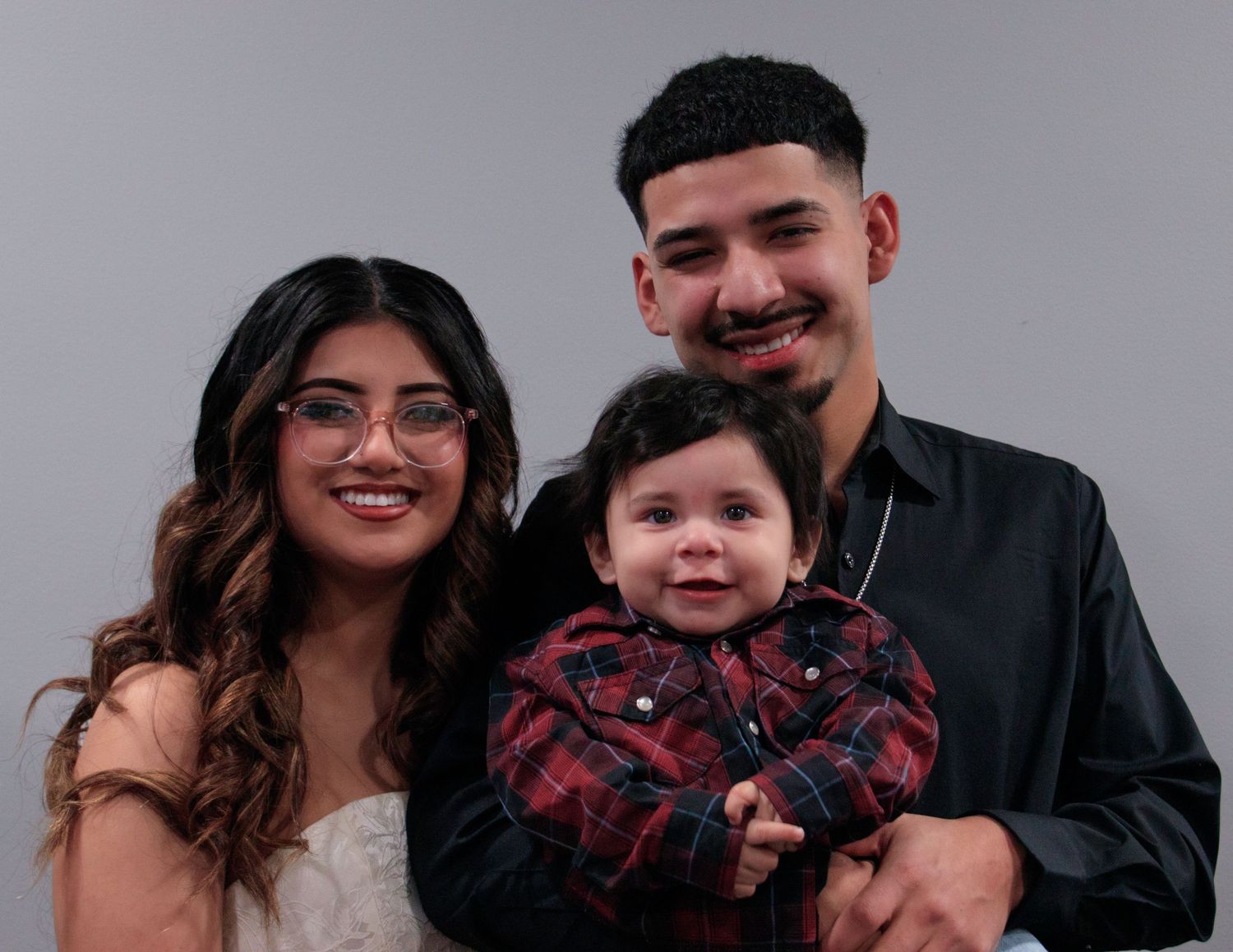 A series of five connected photo booth style images showing a happy family posing together in black and red outfits.