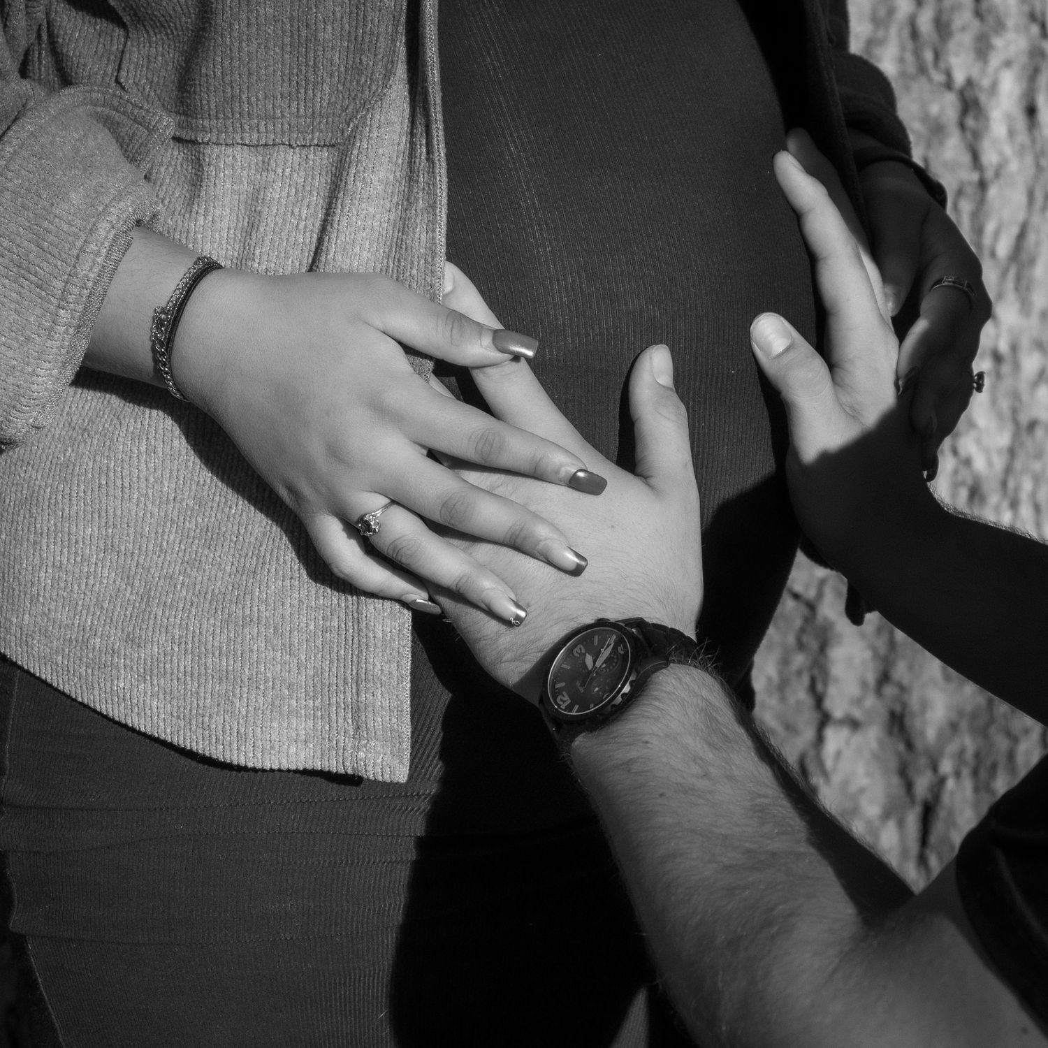 Close-up of hands touching in black and white photography.