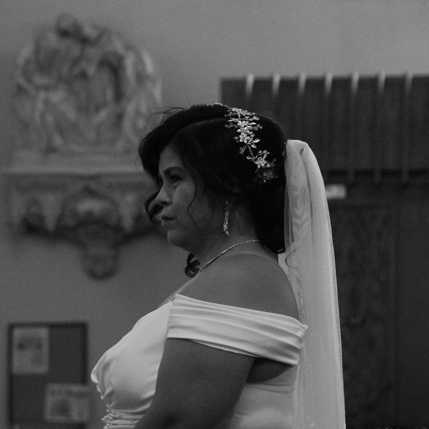 A close-up view of a bride wearing a veil during a wedding ceremony.