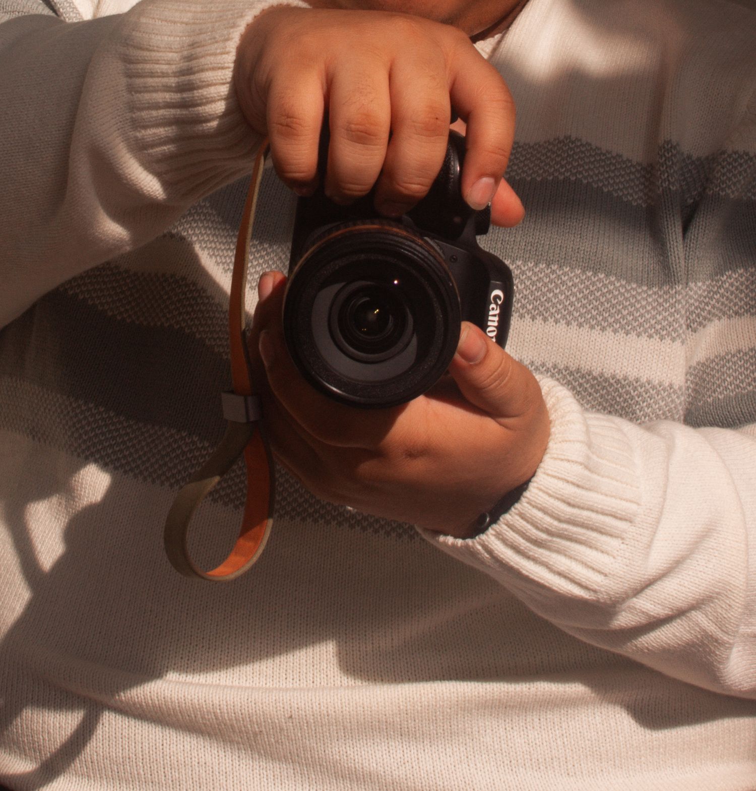 Close-up sequence showing hands holding and adjusting a camera lens.