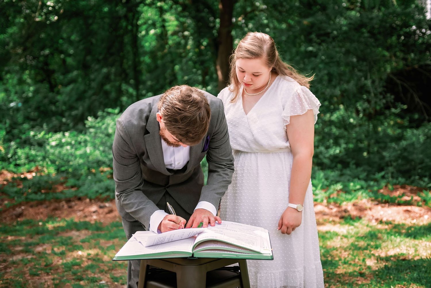 Groom signing marriage certificate with bride nearby; Columbia, SC wedding photography; best photographer Lexington, SC