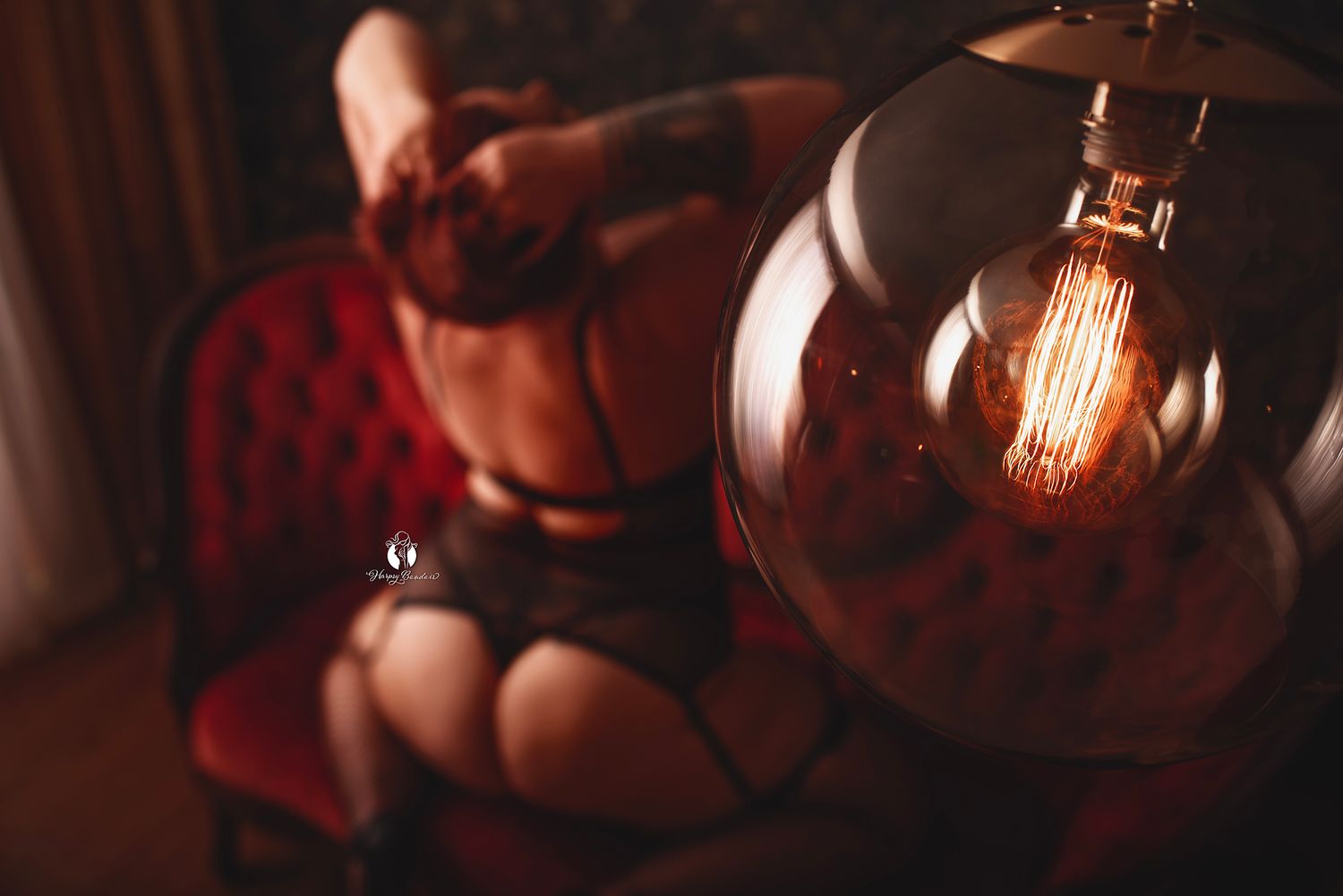 Luxury boudoir photo Lexington, SC, professional boudoir studio; shot through glowing floor lamp with sexy plus-size client in lingerie
