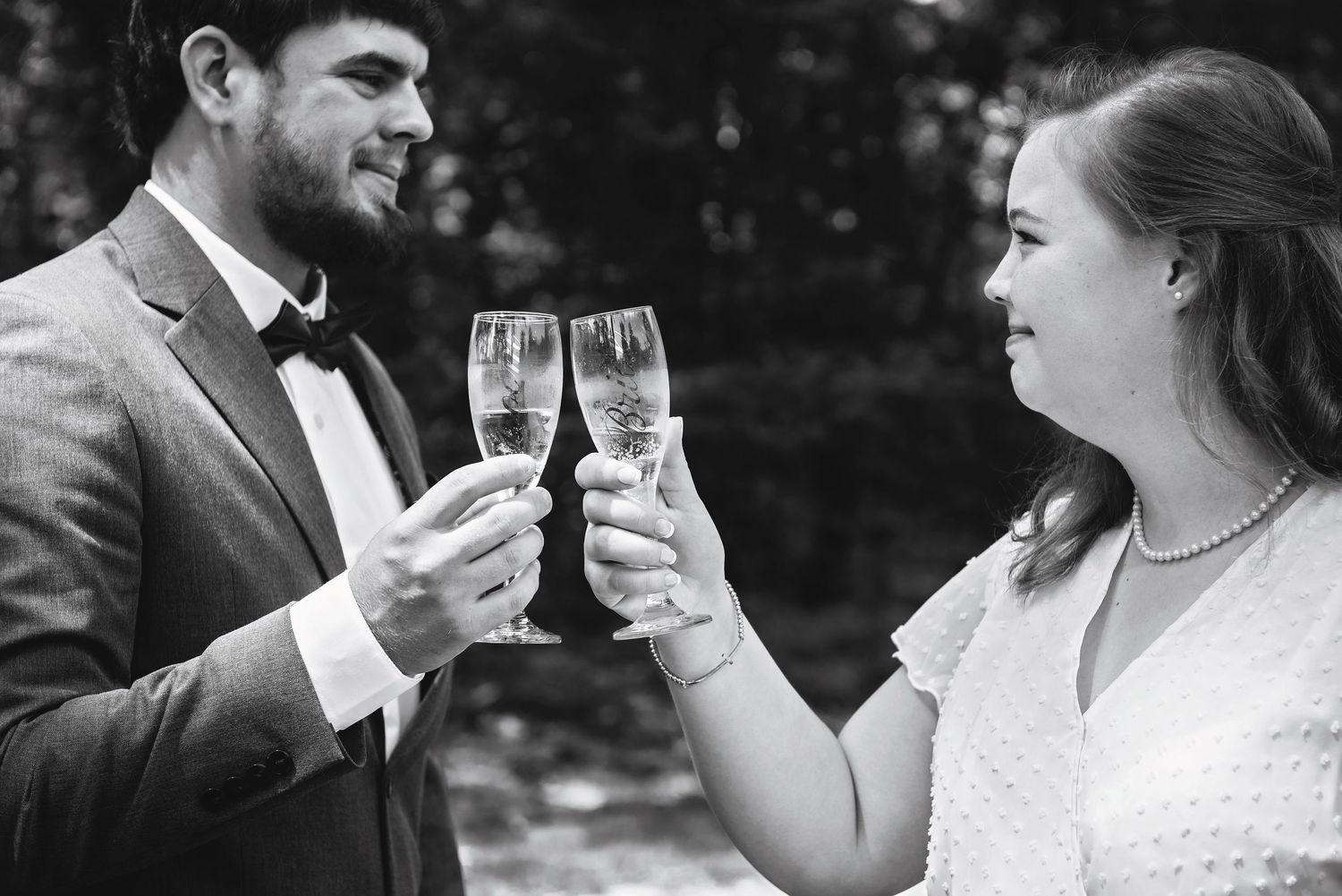 Black & white photo of bride & groom toasting champagne during wedding reception in Lexington, SC; best wedding photographer Lexington, SC