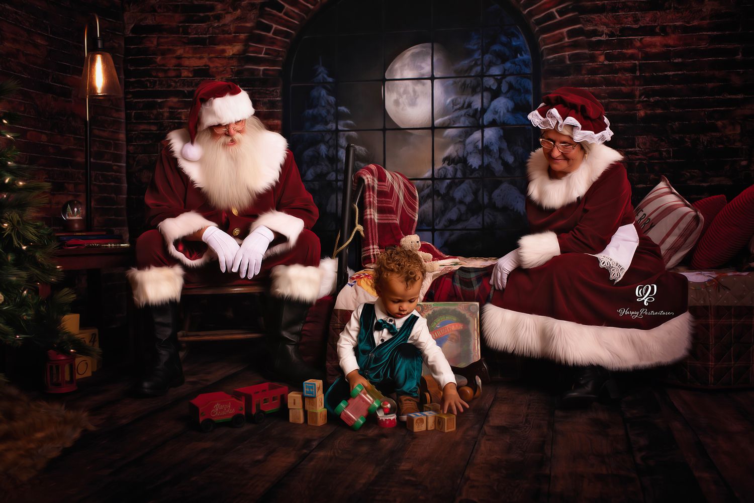 Child in Christmas outfit plays blocks with Santa & Mrs. Claus during Santa mini session in Lexington, SC; pictures with
