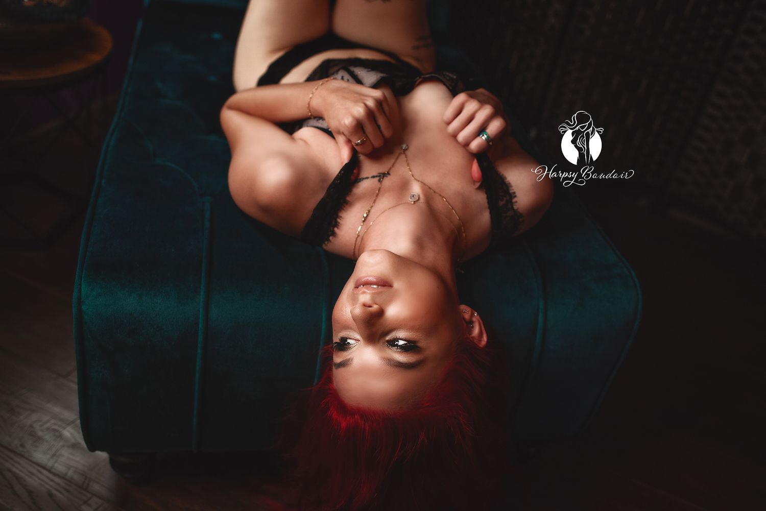 Sexy redhead holds straps of lingerie walk arching and gazing to the side in professional boudoir photoshoot Lexington, SC photographers