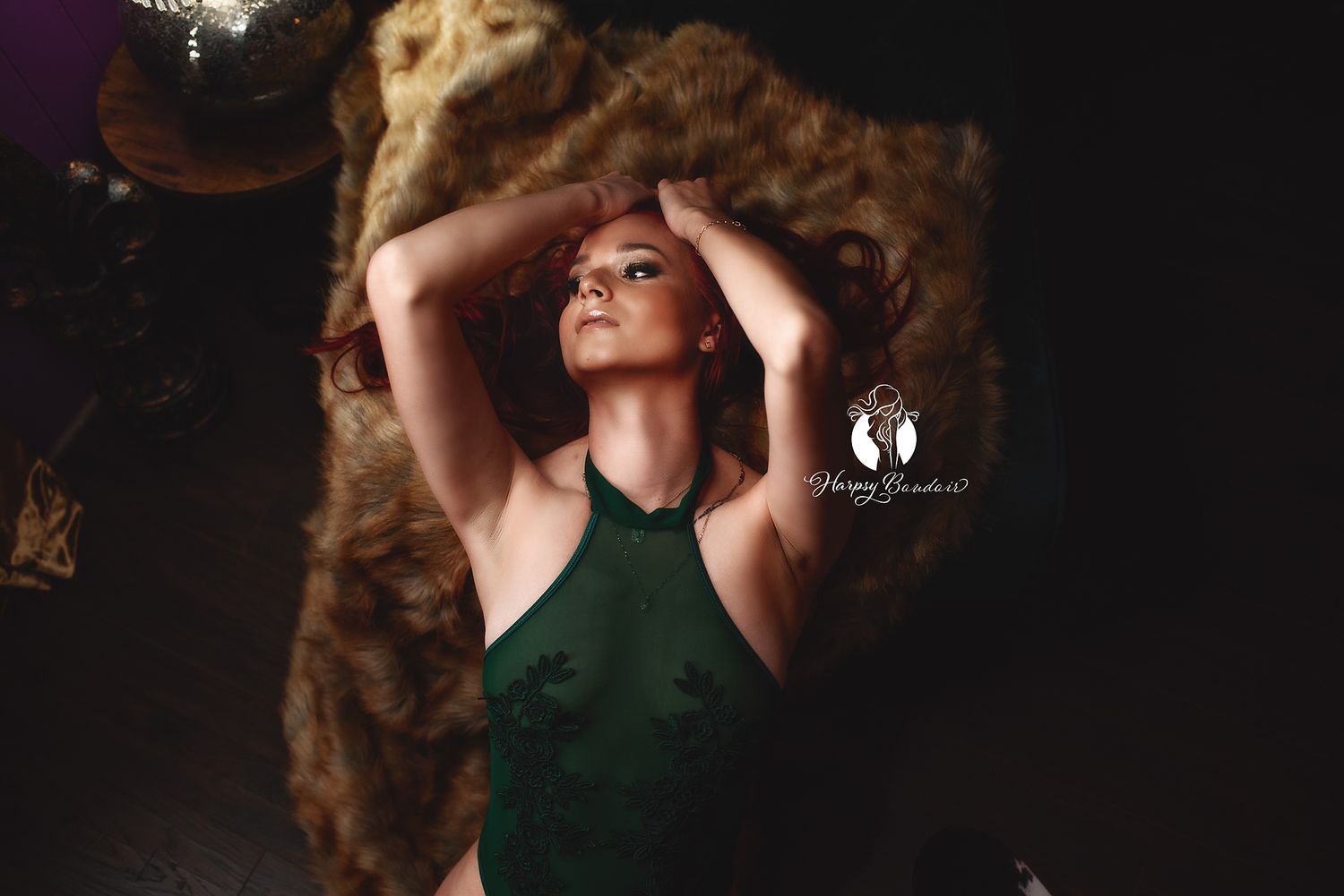 Luxury boudoir photography Lexington, SC, professional boudoir studio; Sexy redhead in lingerie poses with hands in hair on bearskin rug