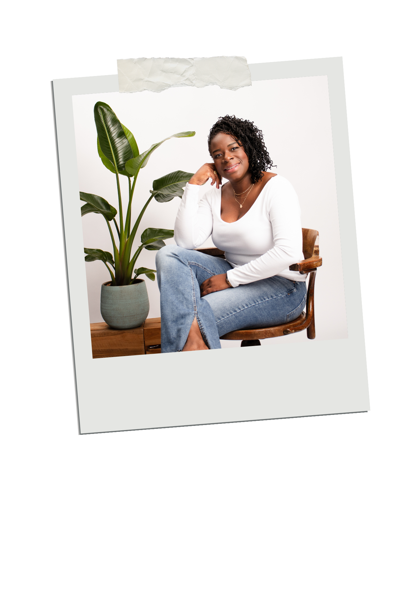 Casual home lifestyle scene showing someone relaxing on a grey couch near a potted plant in a light-filled space.