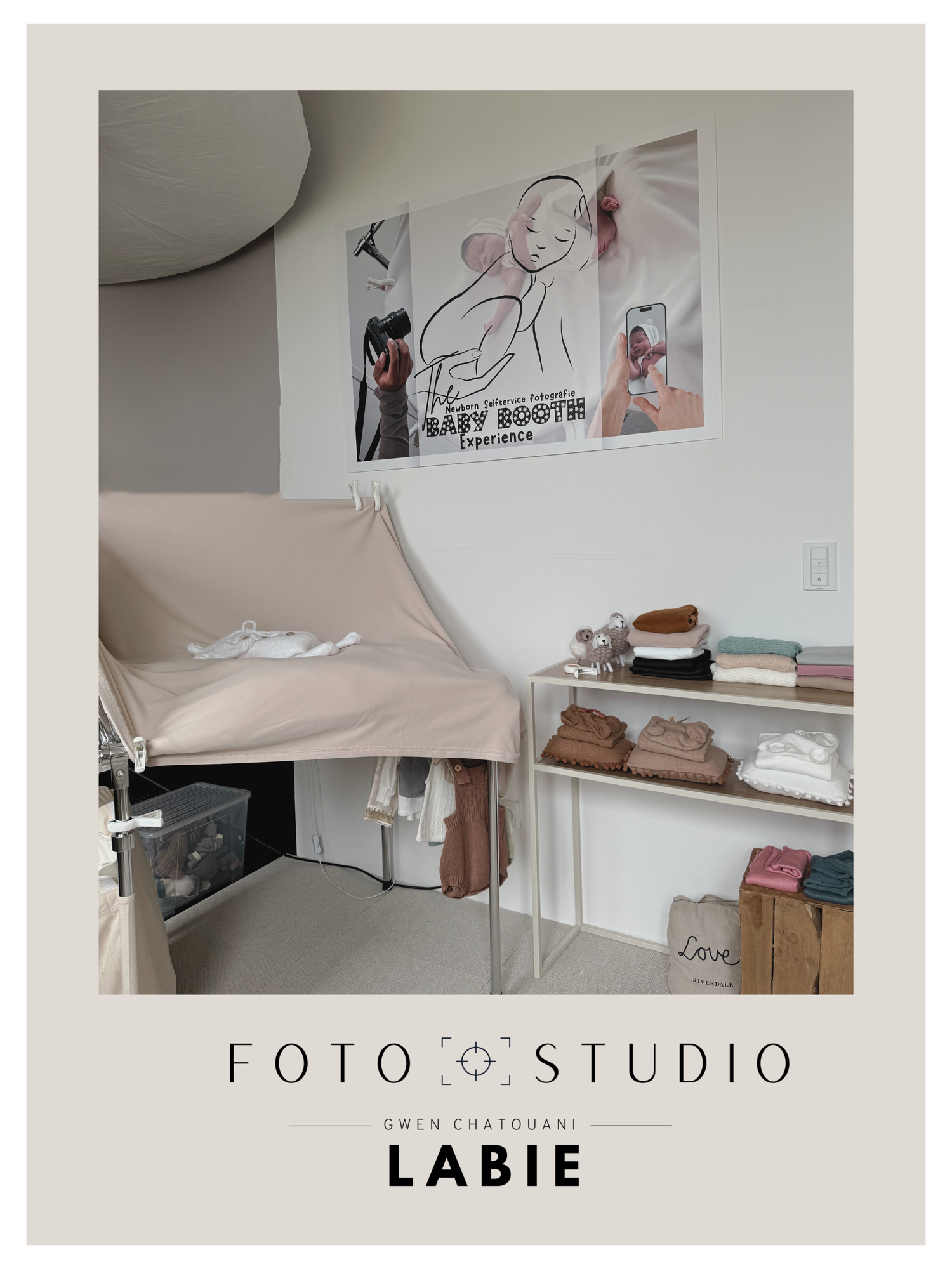 A minimalist interior design studio space with white walls featuring simple artwork and shelving displays.