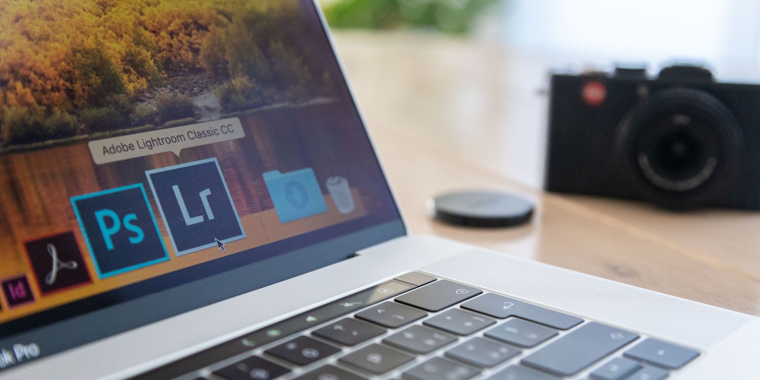 Laptop screen showing Adobe Creative Cloud apps with Photoshop and Lightroom icons next to blurred camera.