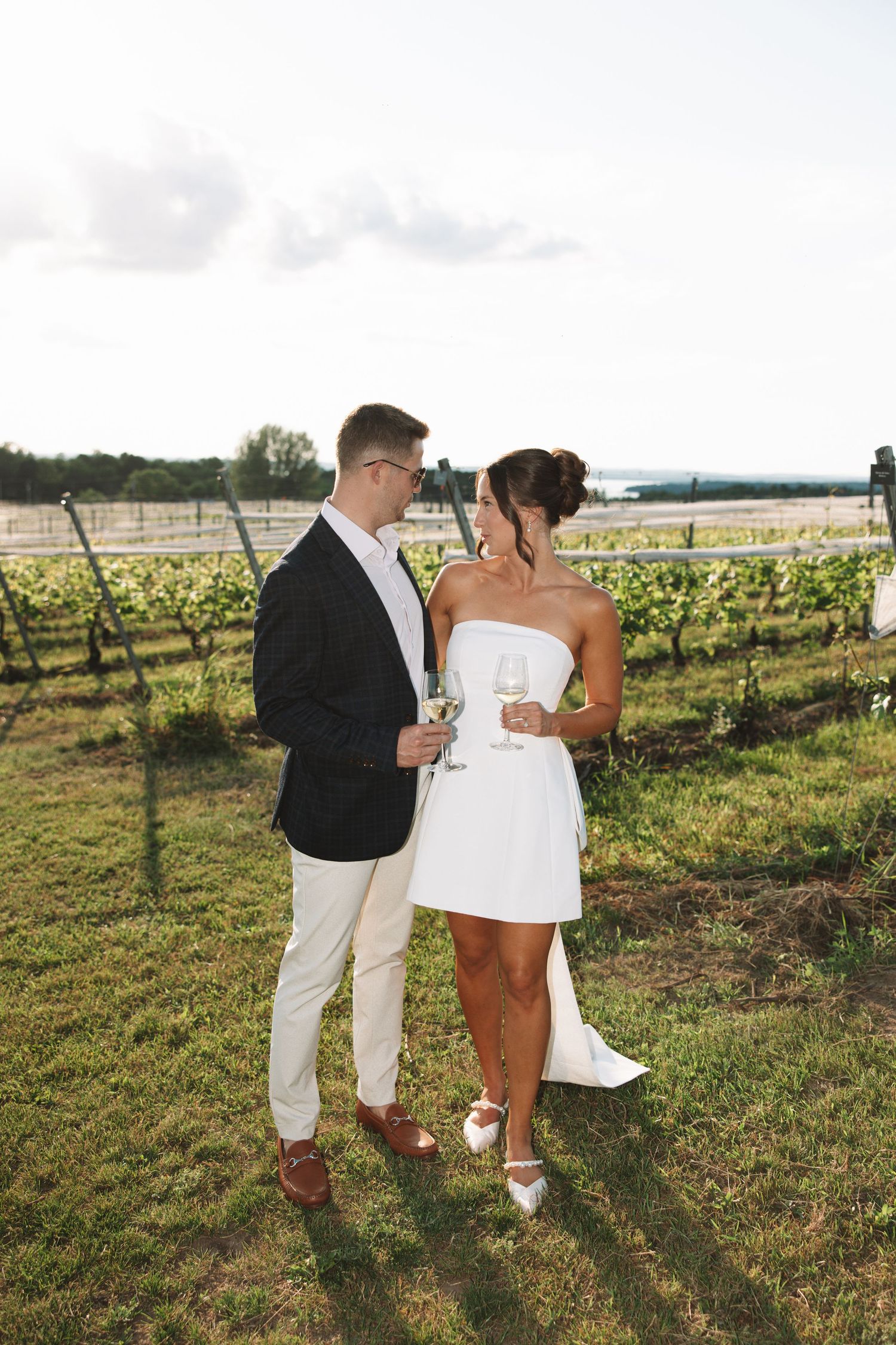 Couple standing together in a vineyard during a rehearsal dinner at a winery