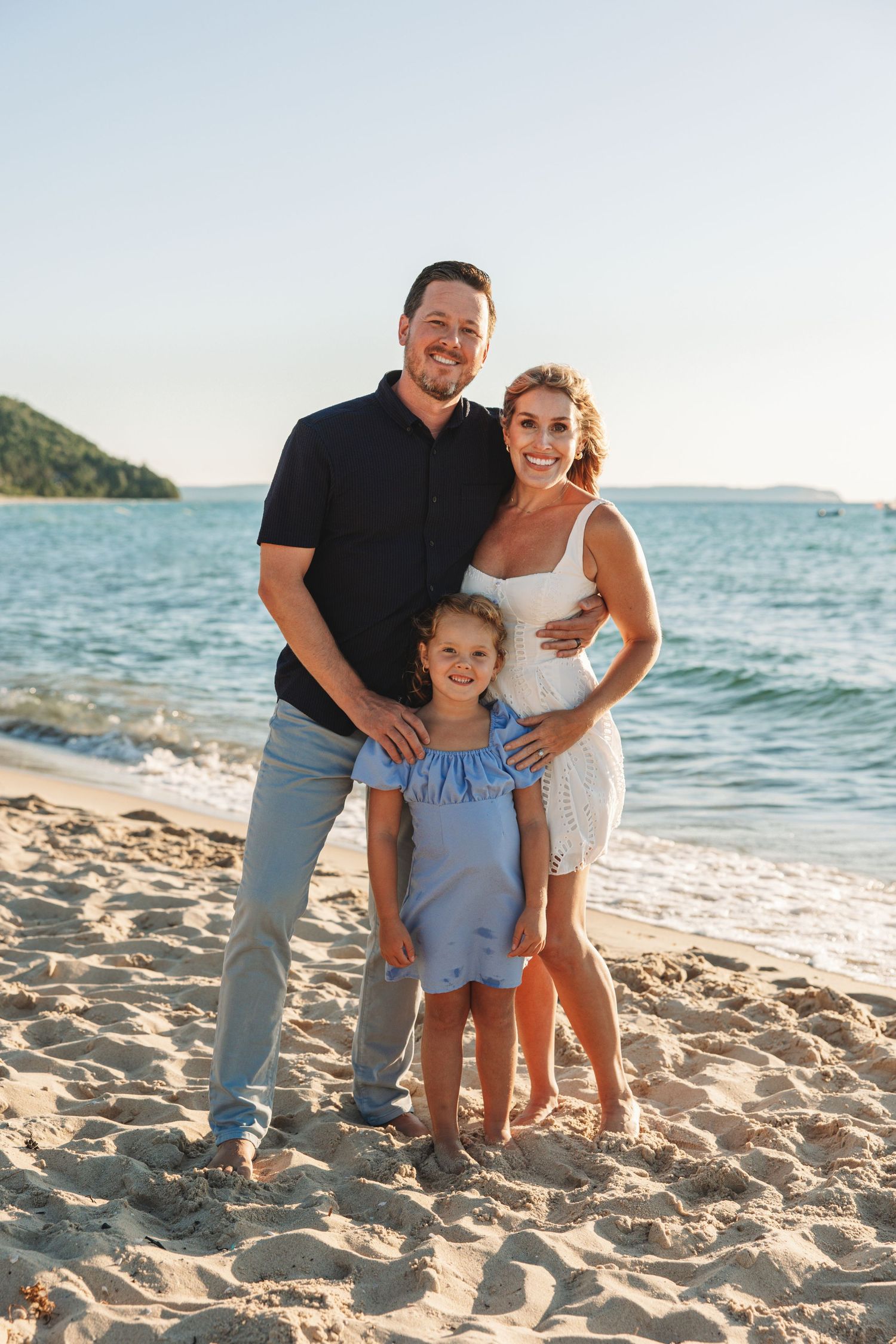 Family standing together on the beach with Lake Michigan in the background during golden hour