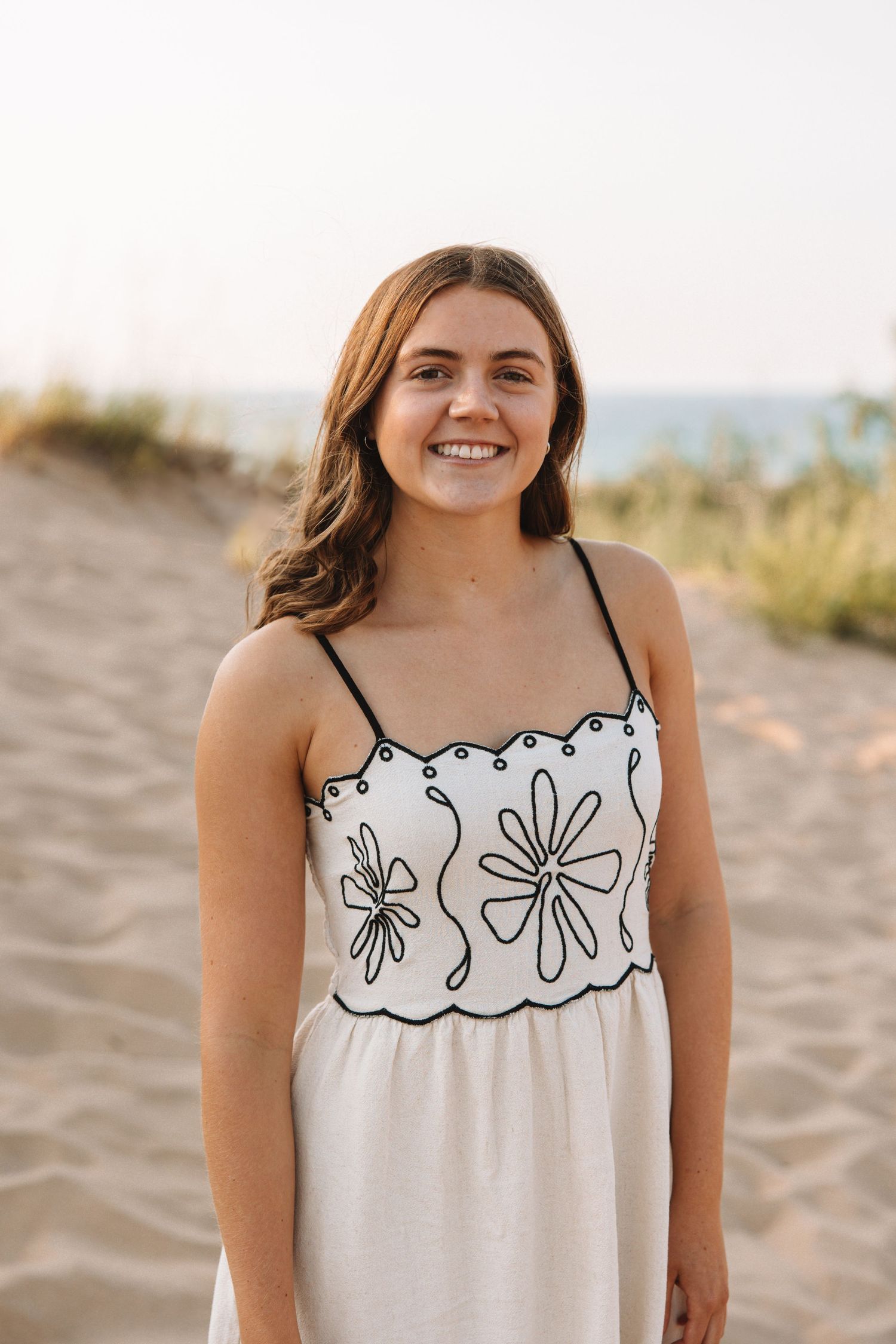 Portrait of a young woman standing on the beach during a natural light photo session