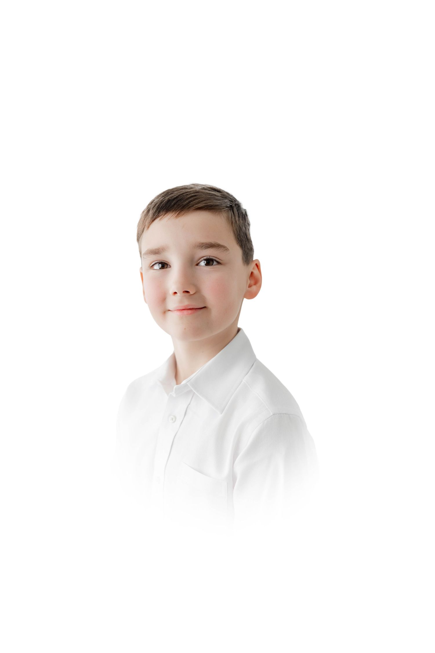 Young boy in white polo shirt smiling against white background, school portrait style photo.