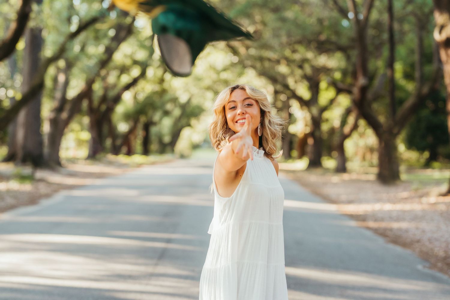 Sunlit outdoor portrait session under tree canopy with natural lighting.