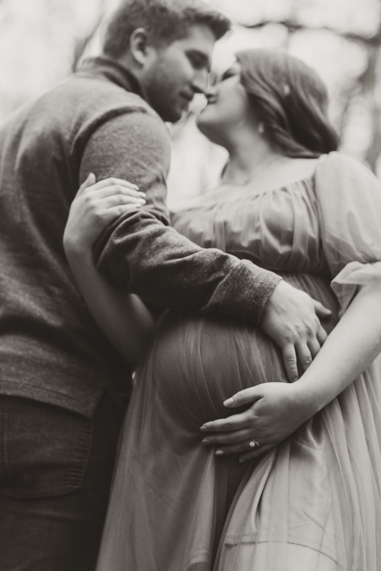 Intimate black and white portrait of couple embracing in romantic moment.