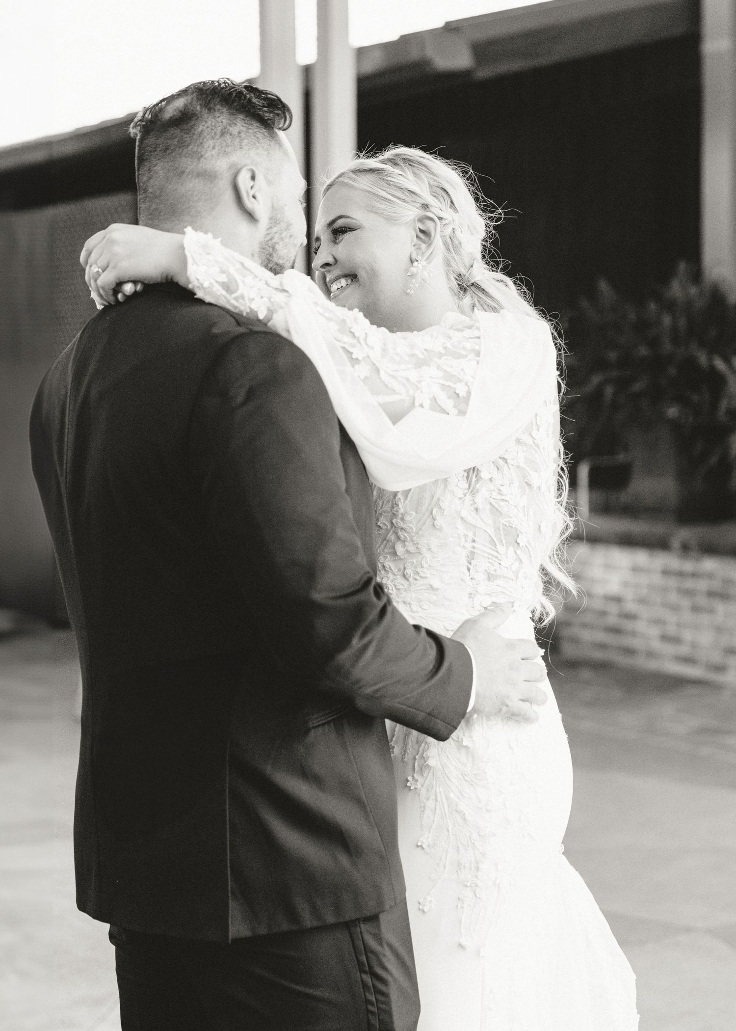 Romantic first dance moment captured between newlyweds in white dress and dark suit.