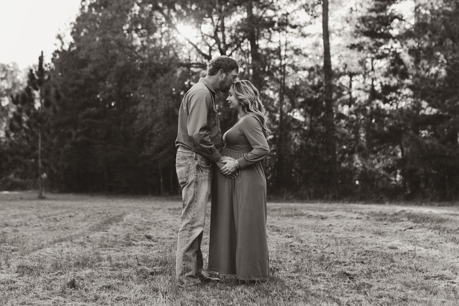 Couple walking together through scenic autumn field at sunset.