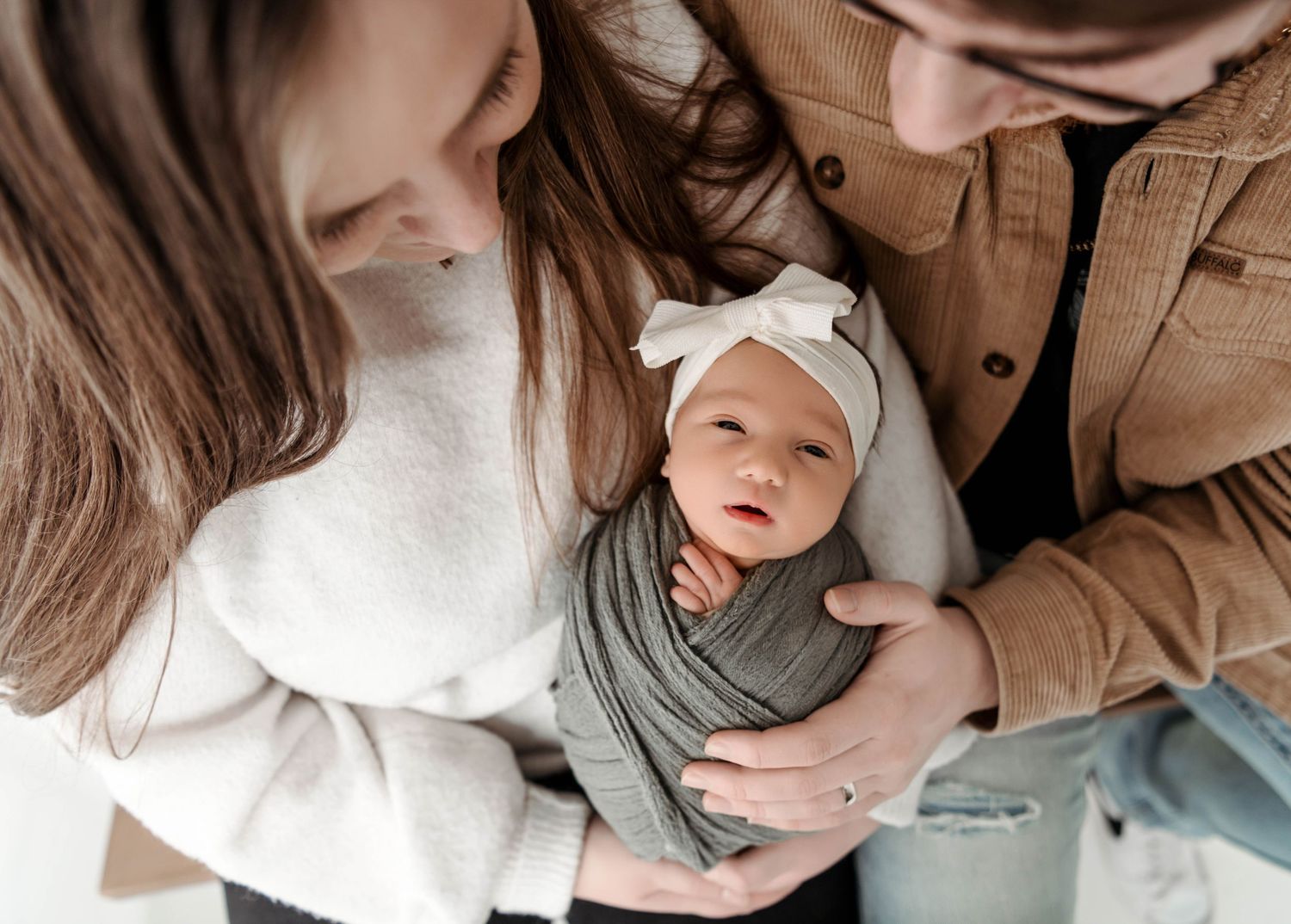 Gentle nurturing moments captured in soft, neutral tones during newborn session.