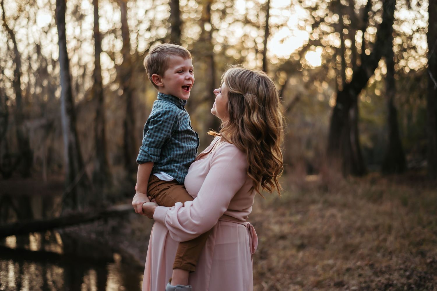 Family maternity portraits in forest setting during golden hour.