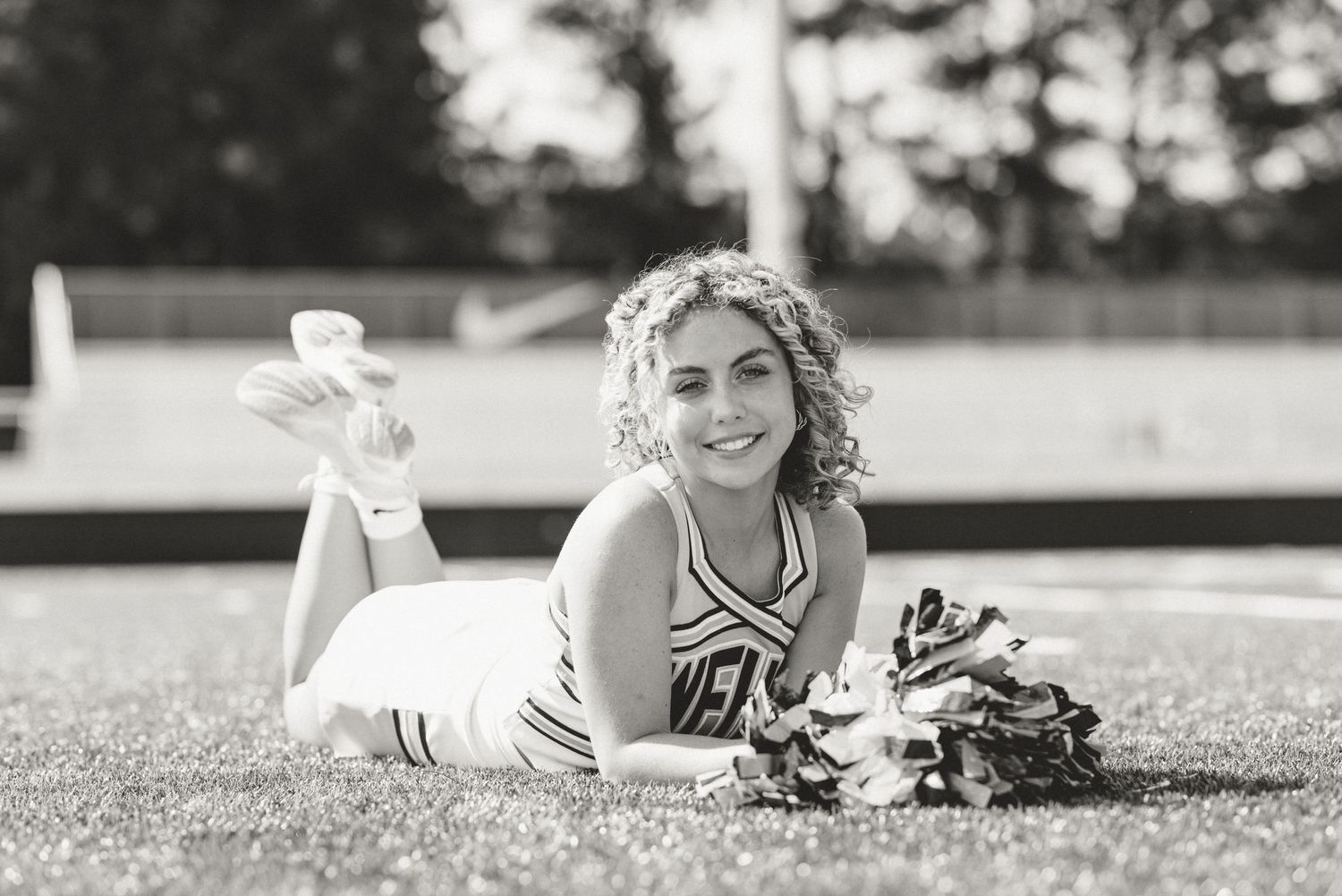 A series of black and white photos showing someone lying in grass with a dreamy expression.