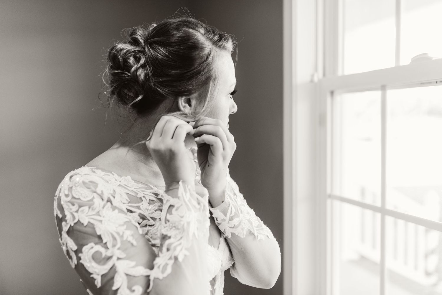 Black and white bridal portrait series showing delicate lace details by window.