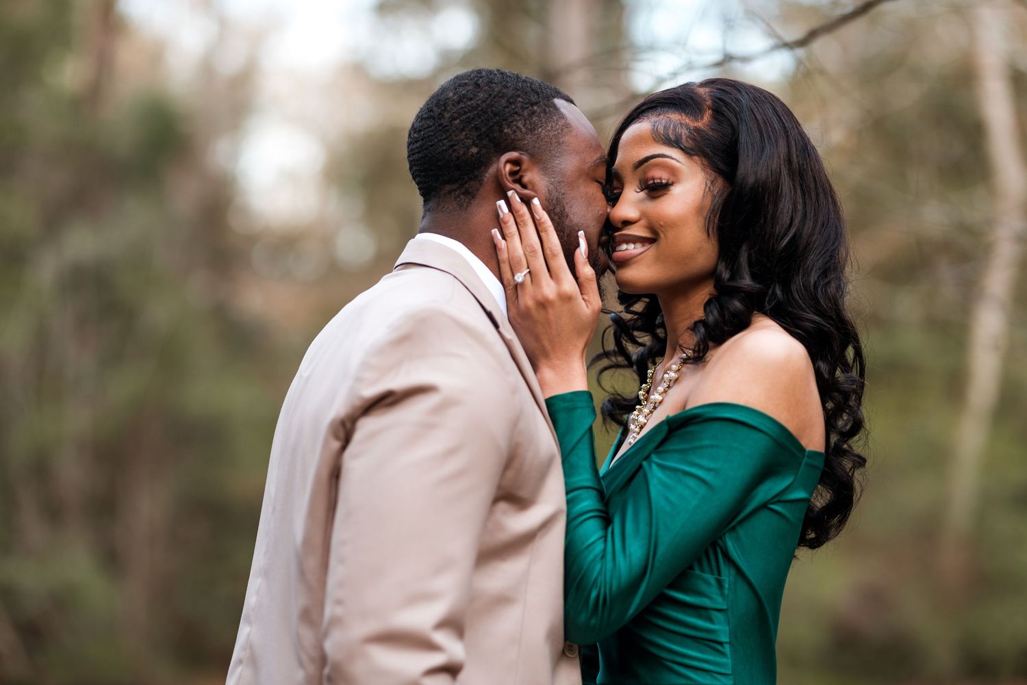 Romantic outdoor photo series of couple in emerald green and beige outfits embracing.