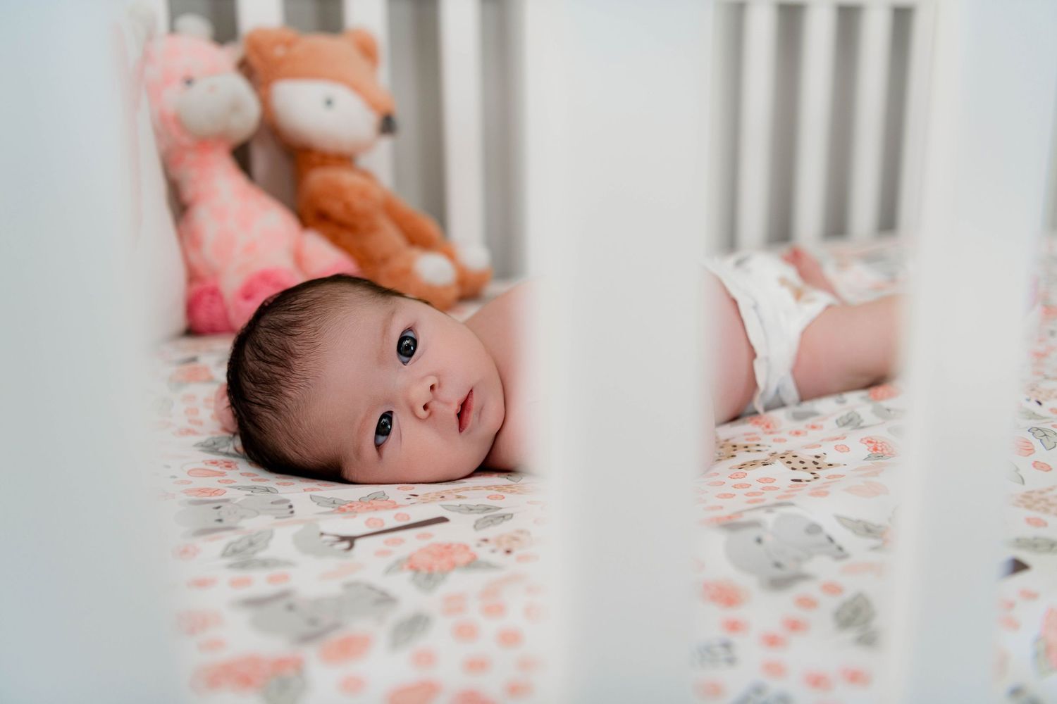 Nursery crib photography with soft floral bedding details.