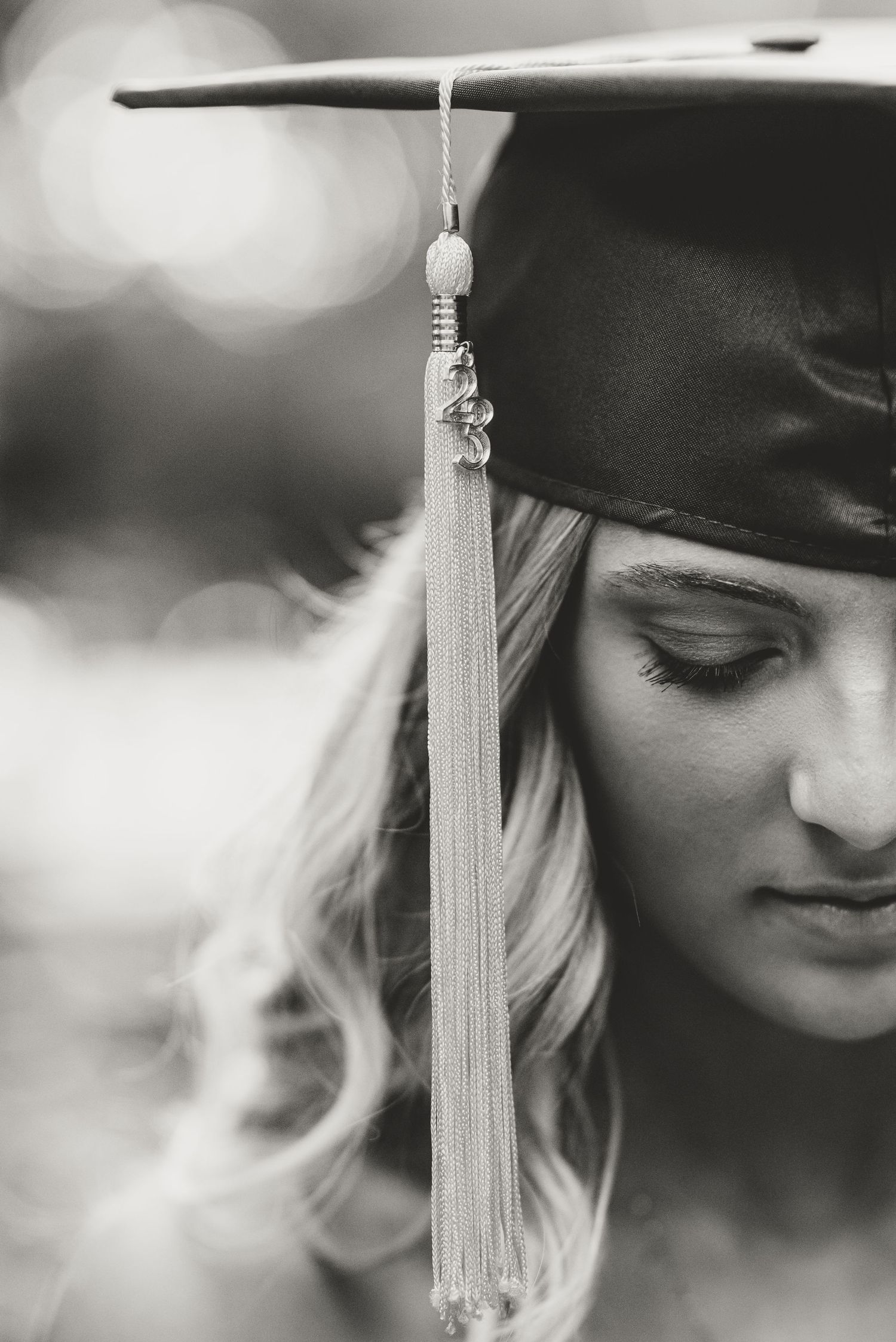 Black and white graduation photo showing tassel hanging from cap.