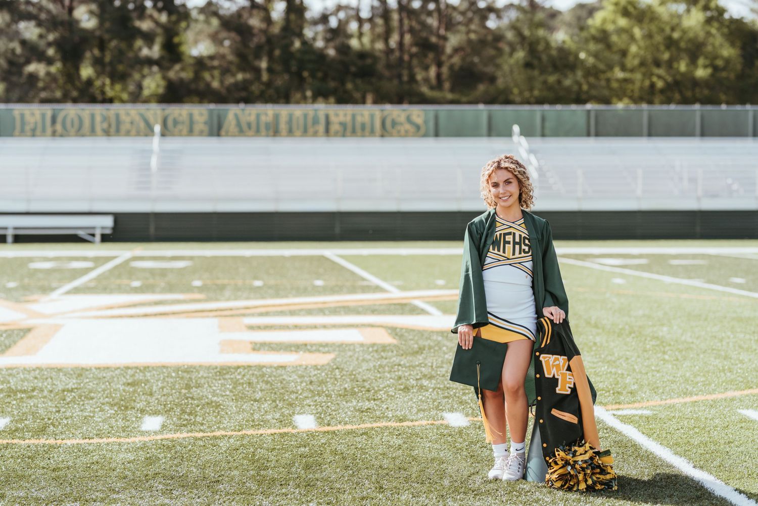 Athletic field with cheerleader and training equipment visible in afternoon light.
