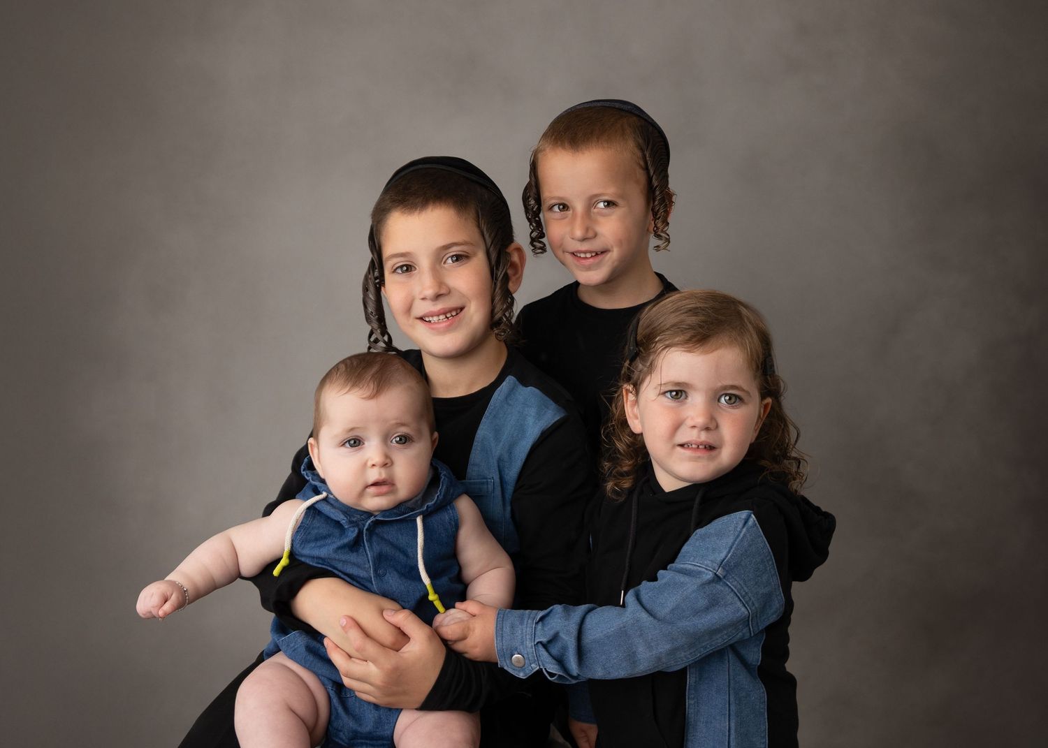 A progressive series of studio portraits showing siblings in coordinating denim and dark clothing against a grey backdrop.