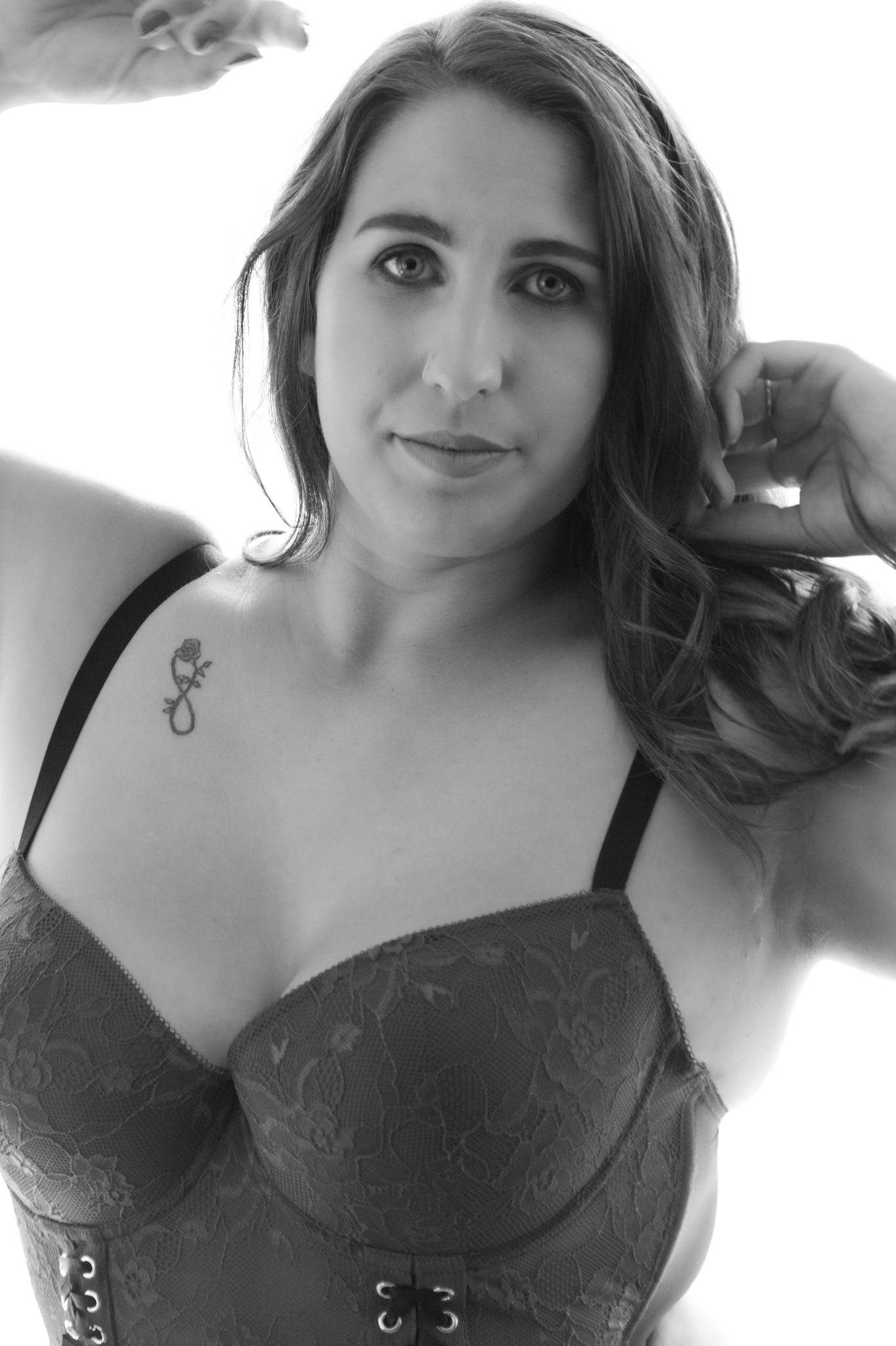 Black and white close-up boudoir portrait of brunette woman in grey lace bra with rose tattoo. Boudoir photography Christchurch