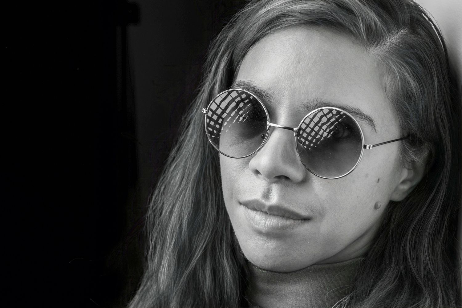 Black and white close-up of a young woman wearing large round patterned sunglasses outdoors. portrait photography Christchurch
