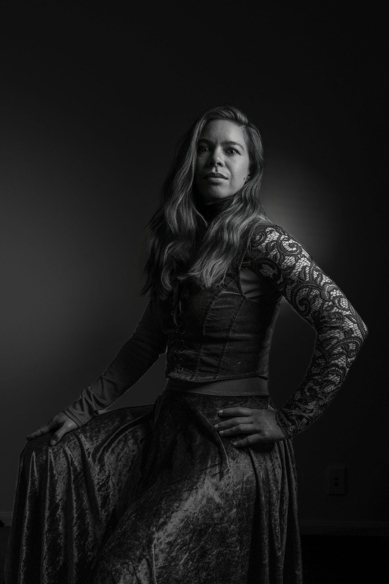 Dramatic black and white studio portrait of a woman in an ornate dark gown with lace sleeves. portrait photography Christchurch
