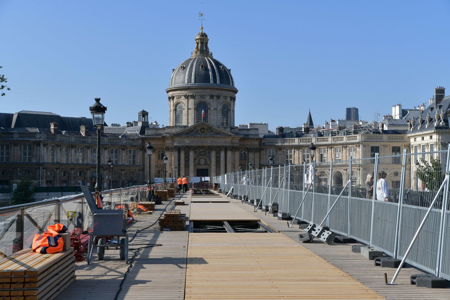 Construction workers renovate a wooden walkway bridge near the Institut de France in Paris, the Pont des Arts.
