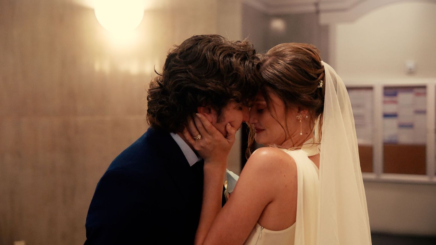 Romantic close-up of bride and groom sharing intimate moment, touching foreheads tenderly.