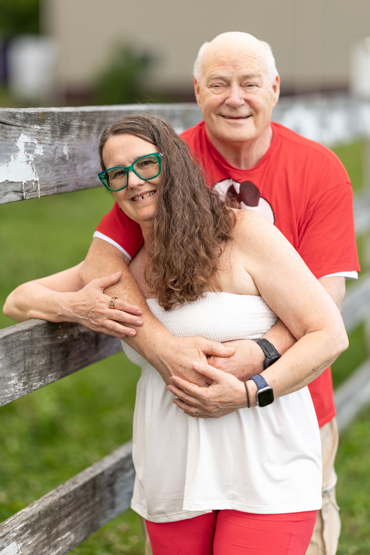 Man puts his arms around woman as she leans on the fence in Yellow Springs, Ohio