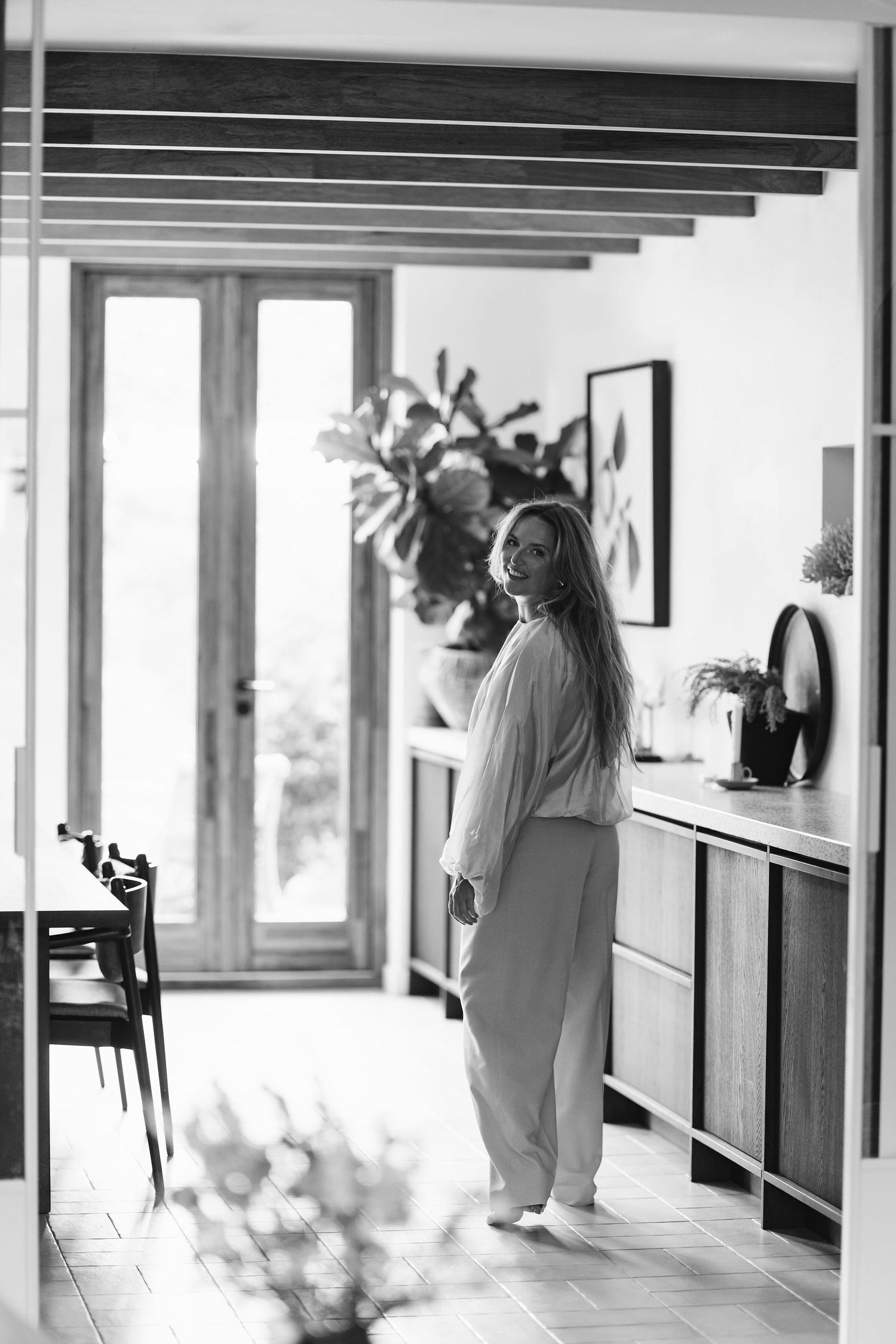 Black and white interior photo showing relaxed home atmosphere with exposed beams.