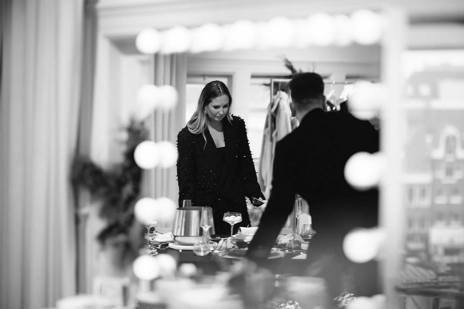 Black and white photo of a shopping experience in an upscale clothing store.