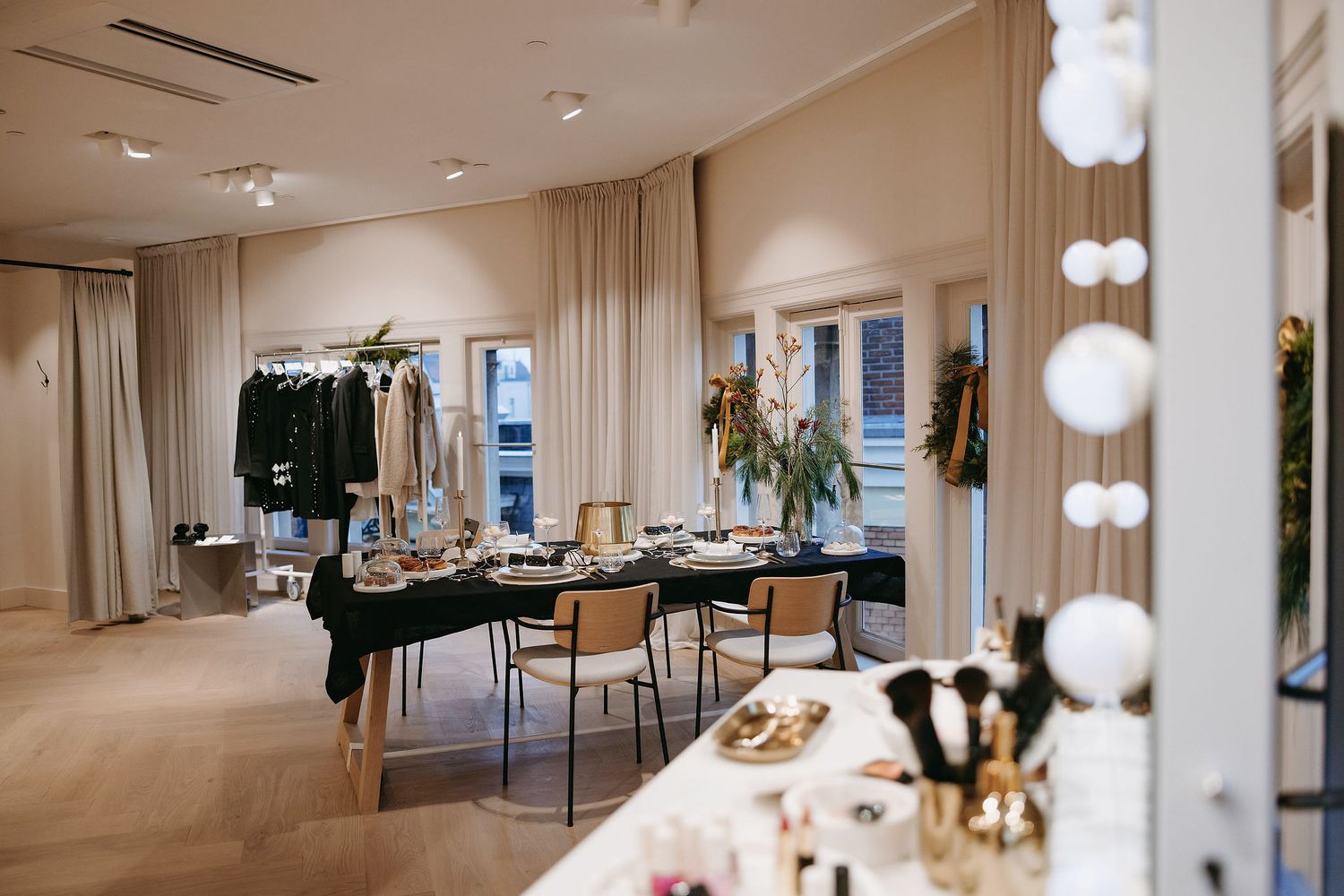 Modern retail space with dining area and makeup stations in neutral tones.