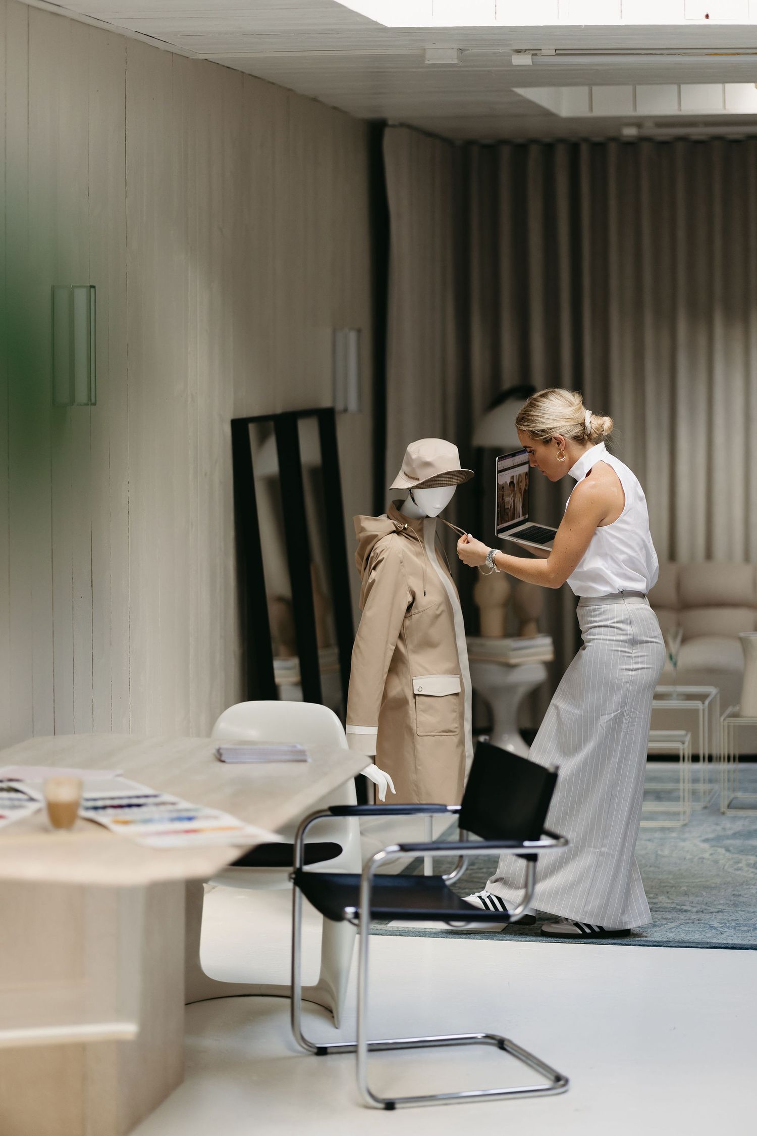 Business setting with clothing racks and office furniture in muted tones.