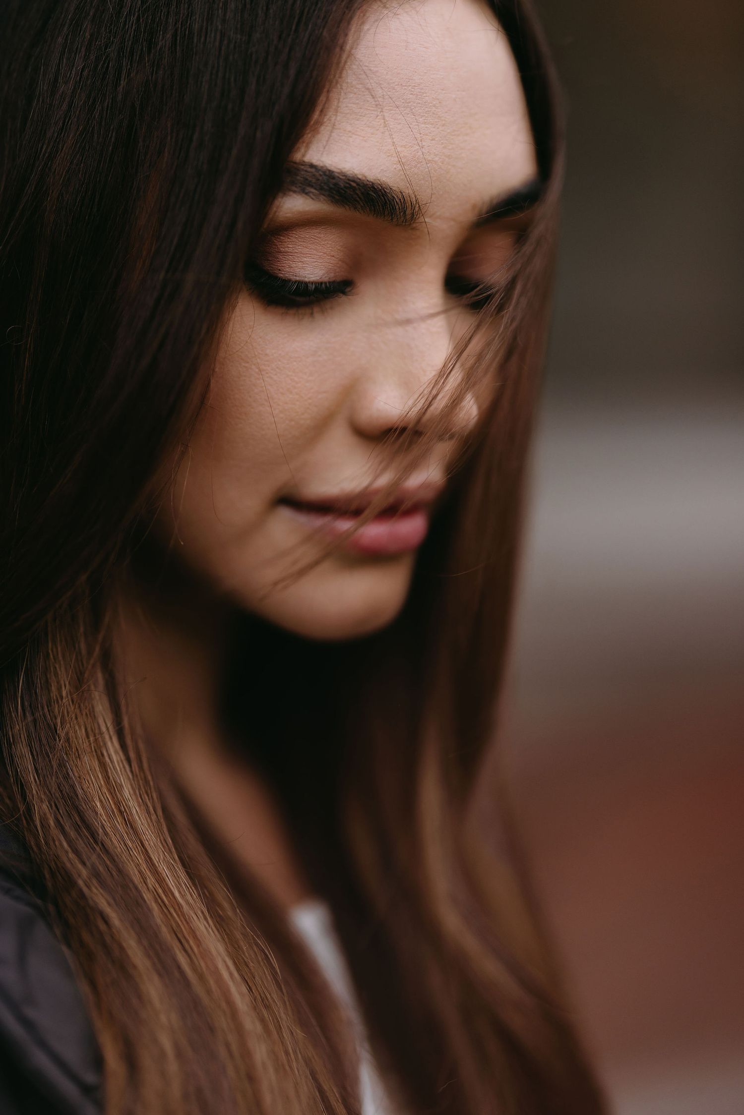 Artistic close-up profile portrait with soft lighting and long brown hair.