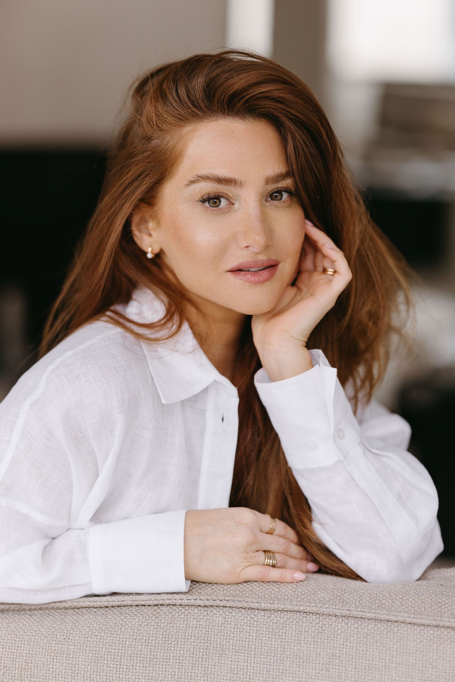 Casual portrait featuring white button-down shirt and natural makeup in soft indoor lighting.