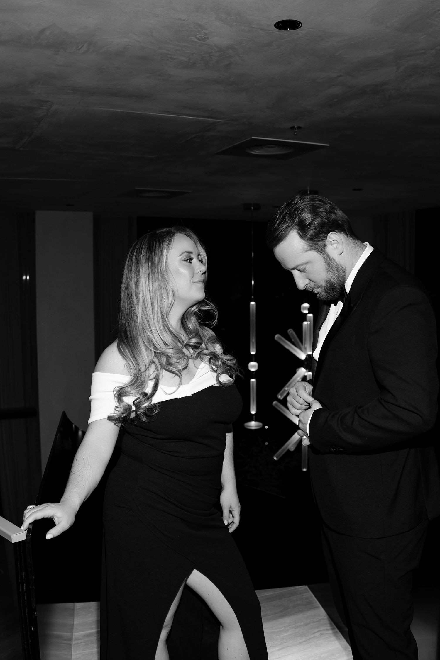 Black and white photo of couple in formal attire dancing at an elegant event.