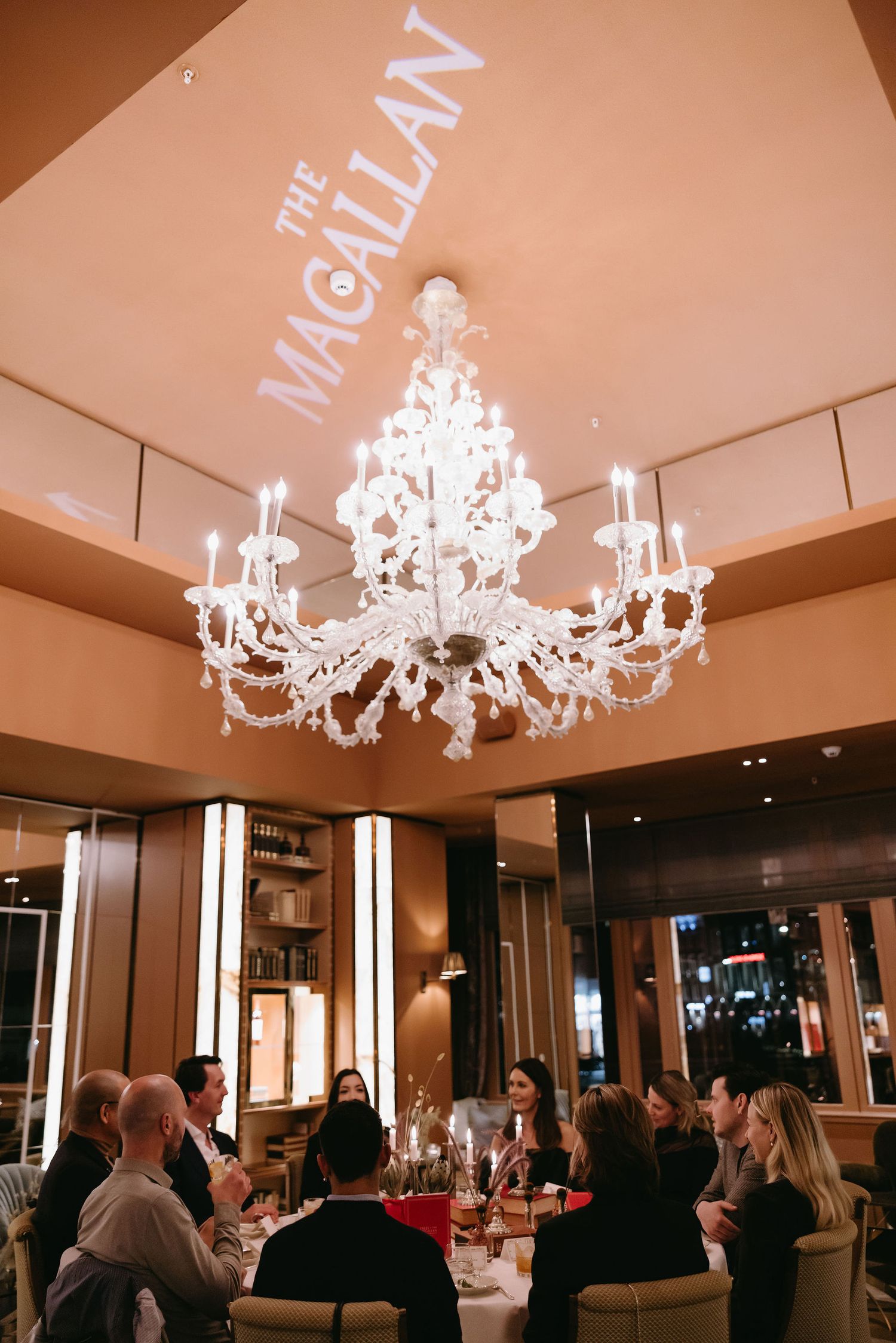 Restaurant interior at The Magellan featuring a stunning white crystal chandelier over dining tables.
