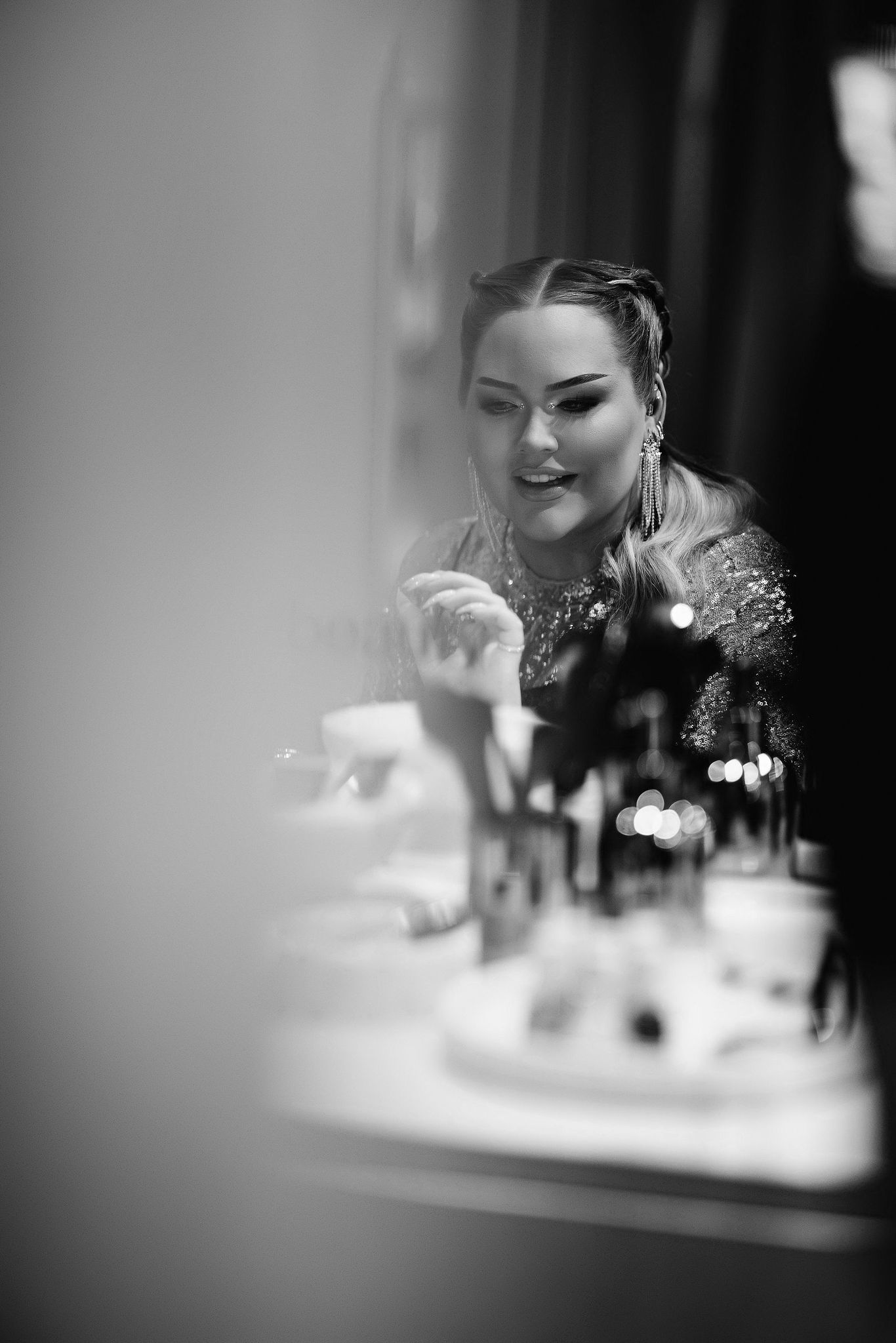 Black and white portrait showing sparkly formal attire and elegant styling at a vanity.