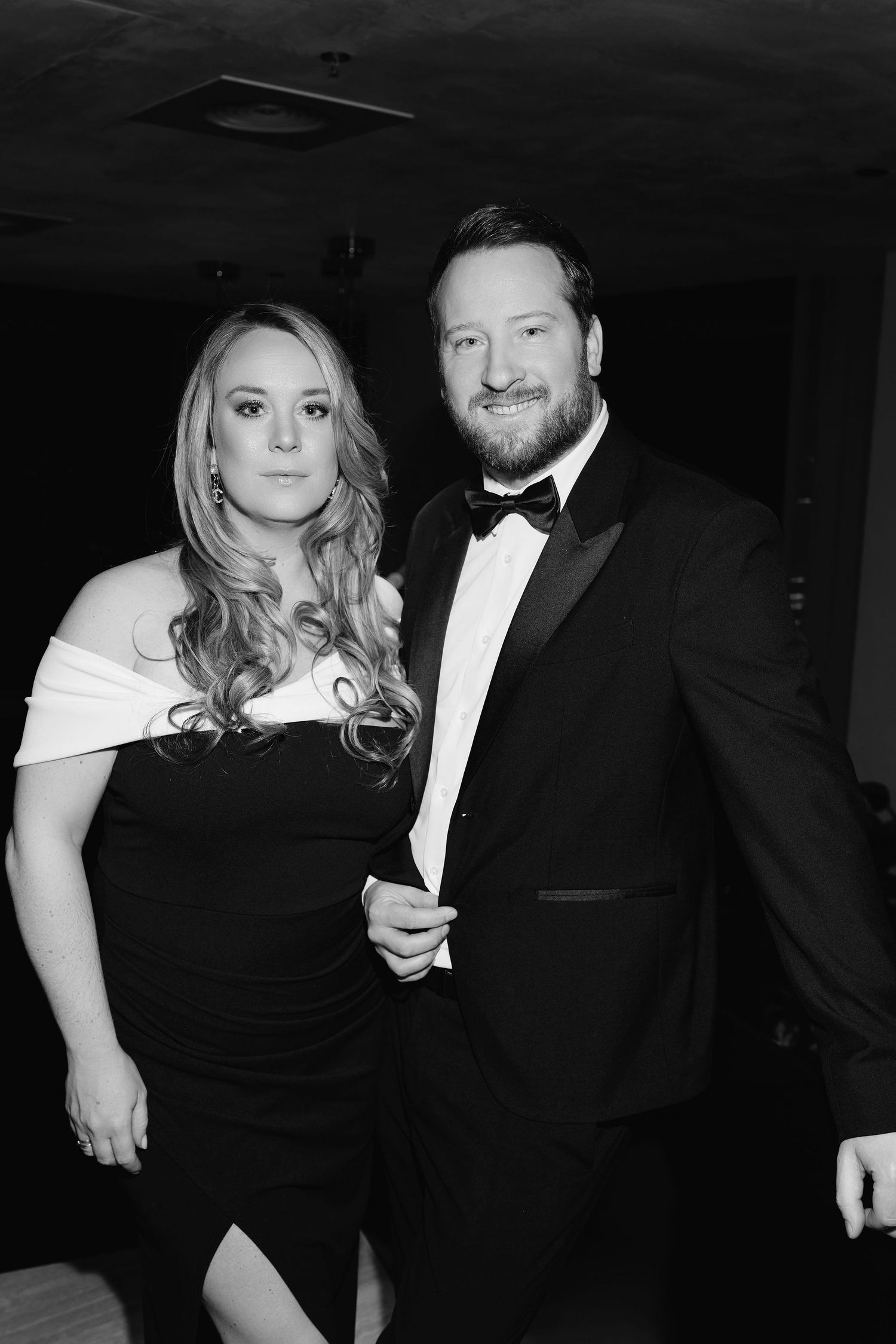 Formal black and white portrait of couple in evening wear at elegant event.