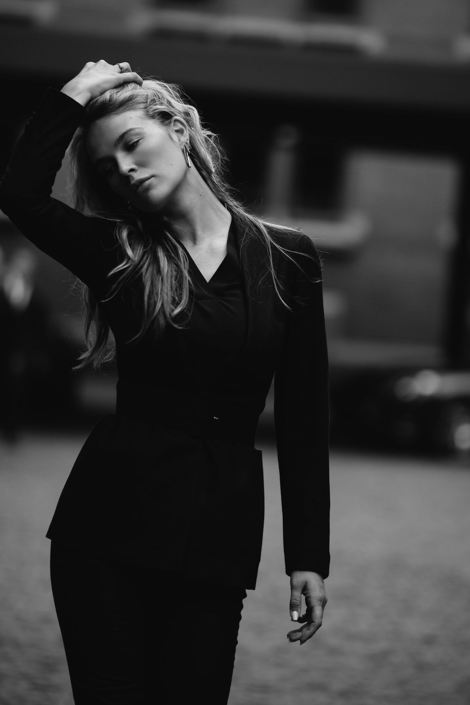 Black and white portrait of a woman in an elegant black dress posing dramatically.