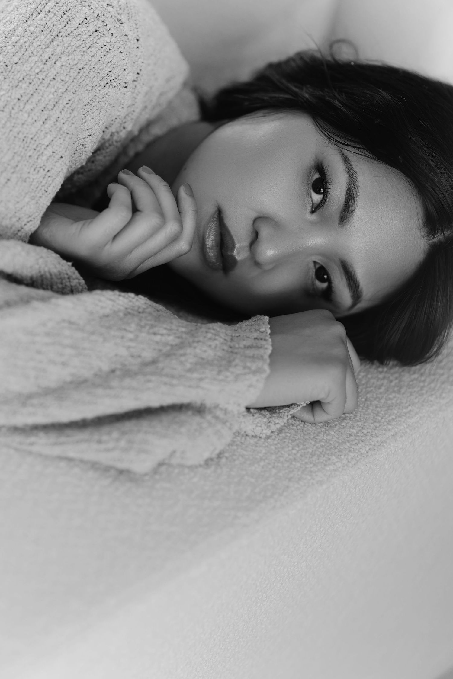 Monochrome close-up portrait in cozy knit sweater with gentle side lighting.